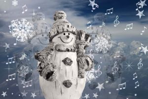 white snowman with a wooden look; grey hat, scarf, and buttons; snow falling around it